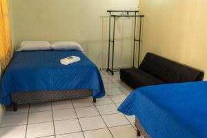 ein Schlafzimmer mit einem Bett und einem Sofa in einem Zimmer in der Unterkunft Villa La Casita in Santa Ana