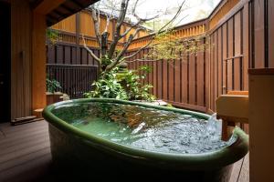a large green bath tub sitting on a patio at Matsudaya Hotel in Yamaguchi