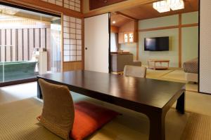 a dining room with a table and a living room at Matsudaya Hotel in Yamaguchi