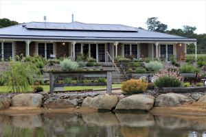 una casa con un estanque delante de ella en Carpe Diem Guesthouse, en Tenterfield