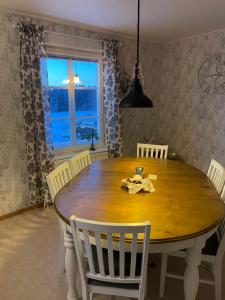 a dining room with a wooden table and chairs at Villa Avaborg in Burträsk