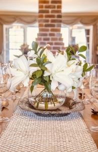 una mesa con un jarrón con flores blancas. en Carpe Diem Guesthouse, en Tenterfield