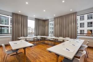 a conference room with tables and chairs and windows at Holiday Inn Express Munich City West, an IHG Hotel in Munich