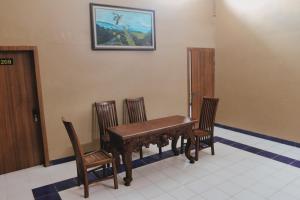 a dining room table with four chairs and a picture on the wall at Hotel Solaris Malioboro in Jetis