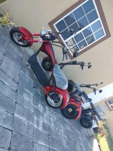 a red scooter parked in front of a house at Orchid Inn at Montego West Village in Montego Bay