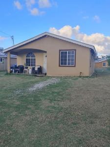 a house with a yard in front of it at Orchid Inn at Montego West Village in Montego Bay