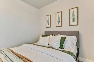 Bett mit weißer Bettwäsche und grünen Kissen in der Unterkunft King Bed Cozy 3BD Condo Full Kitchen in Lehi