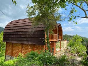 une maison en briques avec une terrasse sur le côté dans l'établissement Suwehan Beach Cliff House by BIJAK, à Polilit