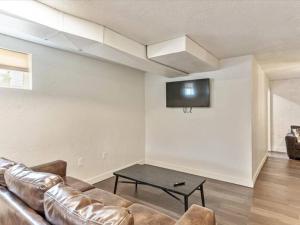 uma sala de estar com um sofá e uma televisão na parede em Queen Beds Great Ski Retreat Park Close By em Midvale