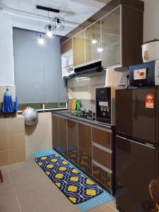 une cuisine avec un réfrigérateur noir et un tapis de cuisine dans l'établissement CASA ZUNAIRA, à Kuala Terengganu