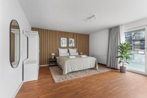 100sqm Luxury Apt in Prime Location near Ku'Damm في برلين: غرفة نوم بسرير ونافذة كبيرة