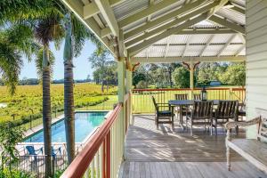 a porch with a table and chairs and a pool at Blair Downs Farm Country Retreat in Cootharaba