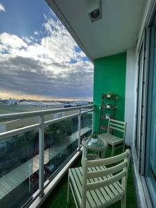 un balcón con 2 sillas y una mesa en un edificio en Azure Beach Club Staycation by Sibs, en Manila
