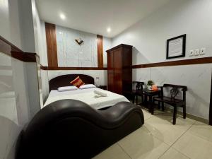 1 dormitorio con 1 cama grande y 1 sofá negro en Khách Sạn Hoàng Hà en Ho Chi Minh