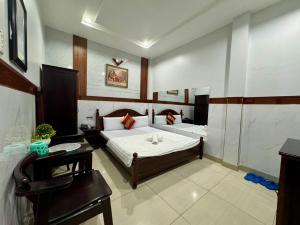 a bedroom with a bed and a desk and a chair at Khách Sạn Hoàng Hà in Ho Chi Minh City