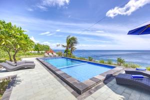 a swimming pool with a view of the ocean at Song Cang Bungalow in Nusa Penida