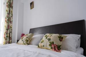Una cama con cabecero negro y almohadas. en OPIA Apartments - Old Town, en Bucarest