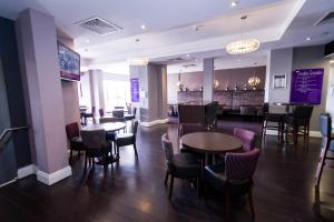 a restaurant with tables and chairs and a bar at Dalmeny Hotel in Lytham St Annes