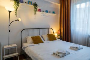 1 dormitorio con 1 cama con toallas en OPIA Apartments - Old Town, en Bucarest