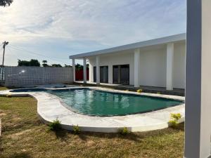 una piscina en un patio junto a una casa en Txumas, en Maputo