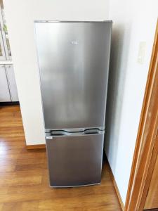 einem Kühlschrank aus Edelstahl in einer Küche in der Unterkunft シークレットベースゆふいん in Yufu