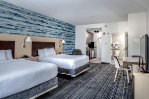 a hotel room with two beds and a desk at TownePlace Suites by Marriott Savannah Airport in Savannah