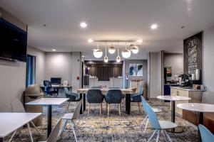 uma sala de jantar com mesas e cadeiras e uma cozinha em TownePlace Suites by Marriott Savannah Airport em Savannah