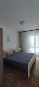1 dormitorio con 1 cama azul grande en una habitación en Apartments Pere - parking and barbecue, en Povljana