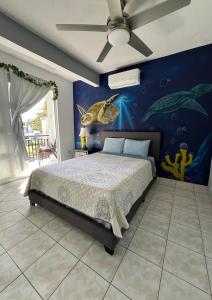 a bedroom with a bed and a painting on the wall at Casita Paraiso in Aguadilla
