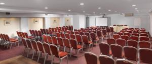 a conference room with red chairs and a podium at Airotel Parthenon in Athens
