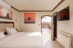 マラケシュにあるRiad Ushuaia La Villa - Centre Marrakechのベッドルーム(白いベッド1台、バルコニー付)