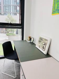 um escritório com uma secretária, uma cadeira e uma janela em Lakeside Apartment with Great Views em Belconnen