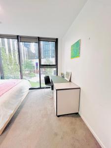 a bedroom with a desk and a bed with a chair at Lakeside Apartment with Great Views in Belconnen