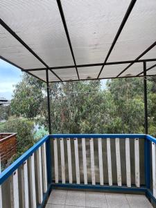 a porch with a blue and white roof and trees at ¡Casa equipada para vacacionar! in Viña del Mar