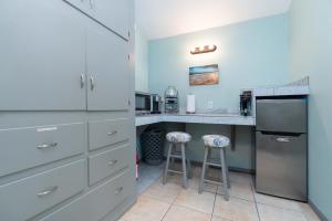 a kitchen with white cabinets and a counter with stools at * - The Leucadia Beach Grotto - * An Encinitas Gem in Encinitas