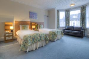 a hotel room with two beds and a chair at The Dolphin Hotel in Great Yarmouth
