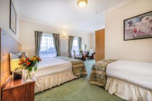 pokój hotelowy z 2 łóżkami i stołem w obiekcie The Dolphin Hotel w mieście Great Yarmouth