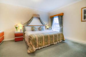 1 dormitorio con 1 cama con dosel en The Dolphin Hotel, en Great Yarmouth