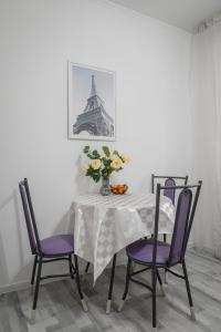 アルマトイにあるКак Дома -квартира в центреのダイニングルームテーブル(紫の椅子付)、花瓶