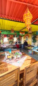 un restaurant avec une table et une tente jaune et rouge dans l'établissement Crazy Camel Hotel & Safari, à Jaisalmer