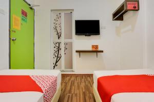 a room with two beds and a tv on the wall at Selesa View Bukit Gambir in Bukit Gambir