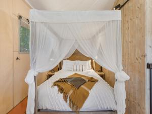 a bedroom with a canopy bed with white curtains at BIG4 Bendigo Marong Holiday Park in Marong