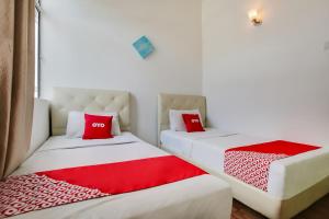 two beds with red pillows in a room at Selesa View Bukit Gambir in Bukit Gambir