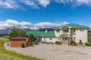 Casa blanca grande con techo verde en Waterton Country Villas, en Waterton Park