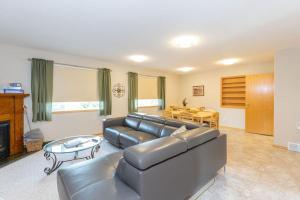 a living room with a leather couch and a table at Waterton Country Villas in Waterton Park