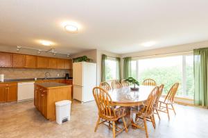 cocina con mesa, sillas y nevera en Waterton Country Villas, en Waterton Park