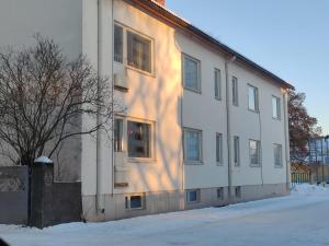 a building with the sun shining on the side of it at Studio Porin Oksi, home away home in Pori city center, free parking in Pori