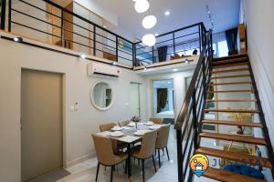 a dining room with a table and a staircase at Arte Cheras by Just Stay in Kuala Lumpur