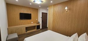 Cette chambre comprend un lit et une télévision à écran plat. dans l'établissement HOANG LINH PHAT HOTEL, à Đà Lạt