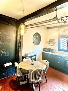 ein Esszimmer mit Tisch und Stühlen und einer Uhr in der Unterkunft Little Libertys in Shrewsbury